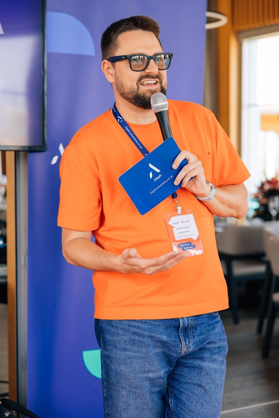 Evgeny Kozlov speaking with a microphone at an Aleph and Reddit event in Cyprus